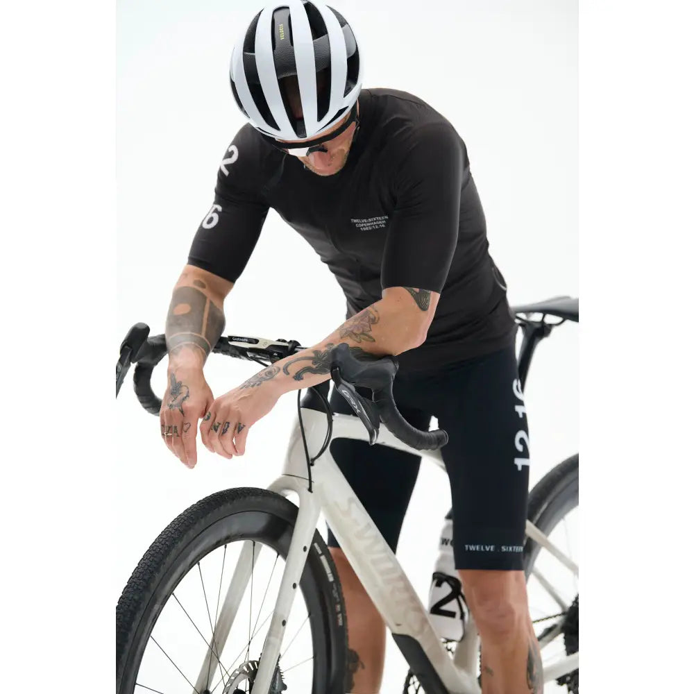 Cyclist in black TwelveSixteen outfit and helmet 