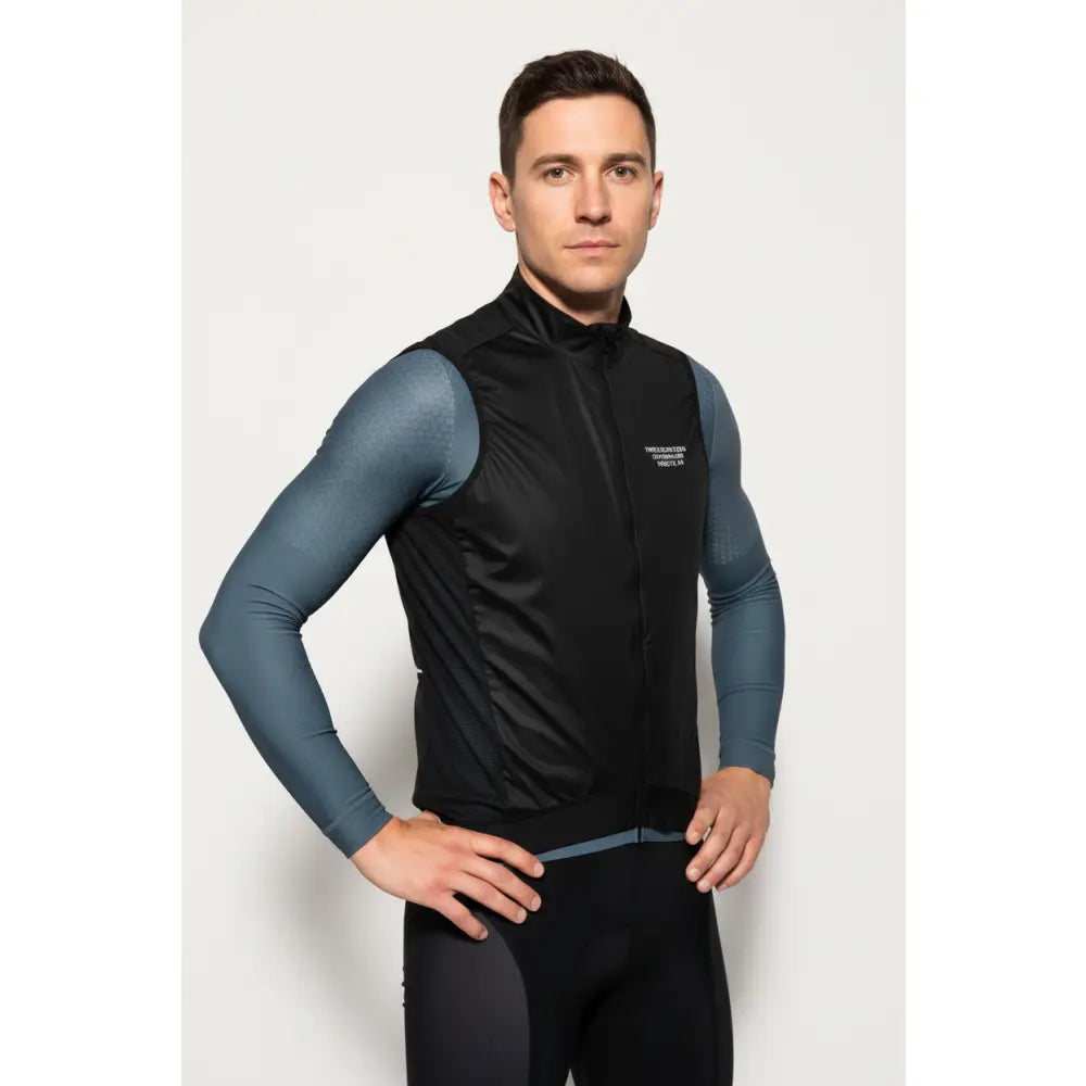 Man wearing a black vest over a blue long-sleeve shirt 