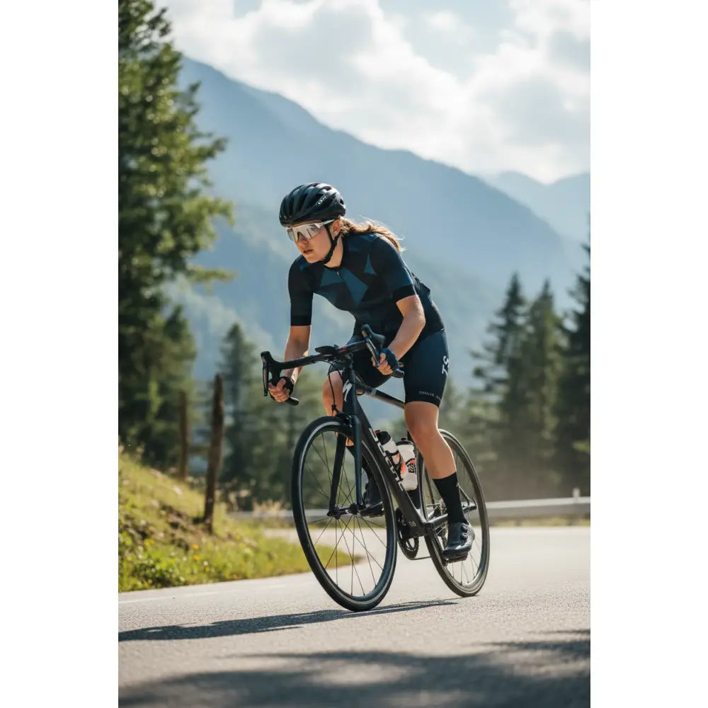 Person cycling on a mountain road with scenic background