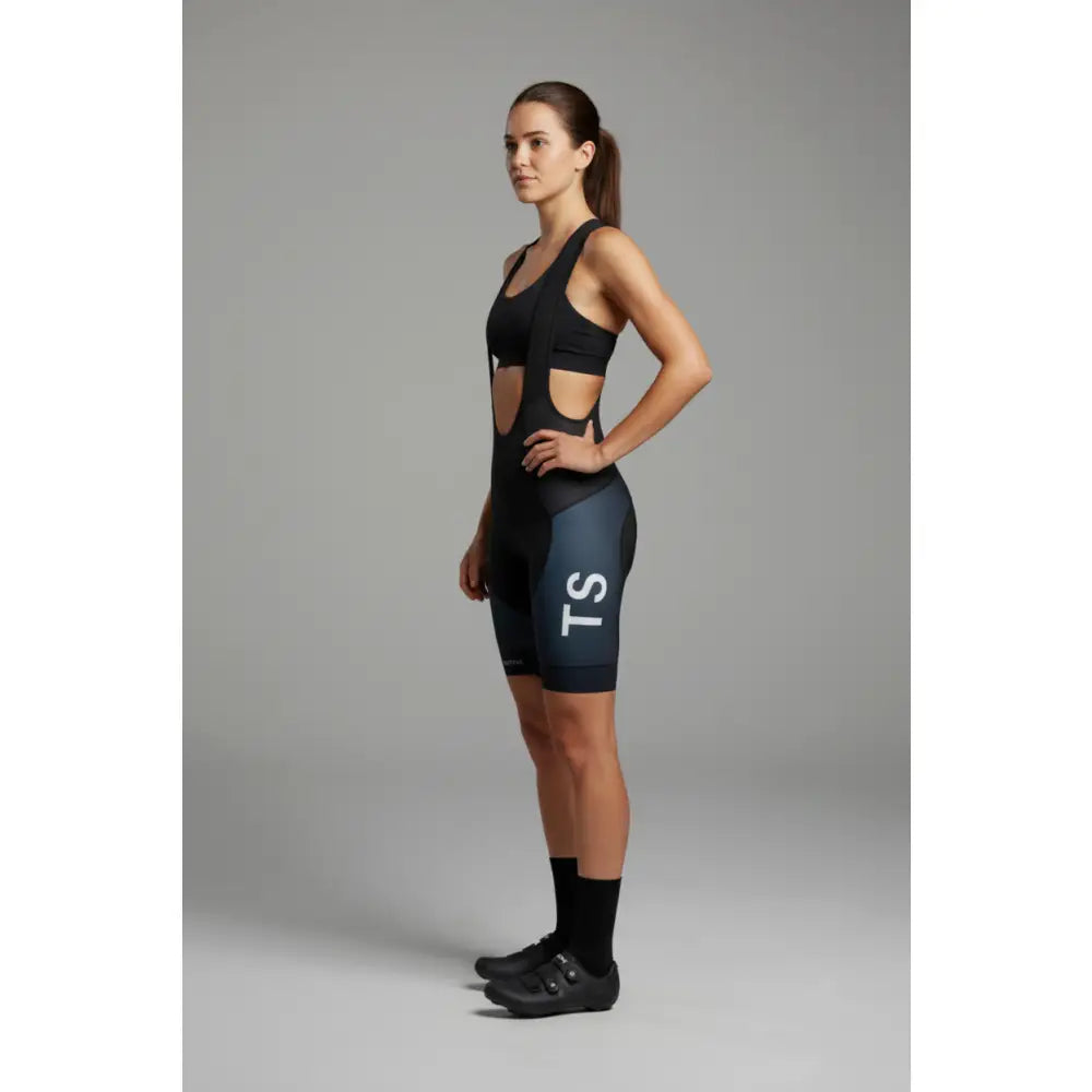 Woman wearing a black athletic outfit with 'TS' 