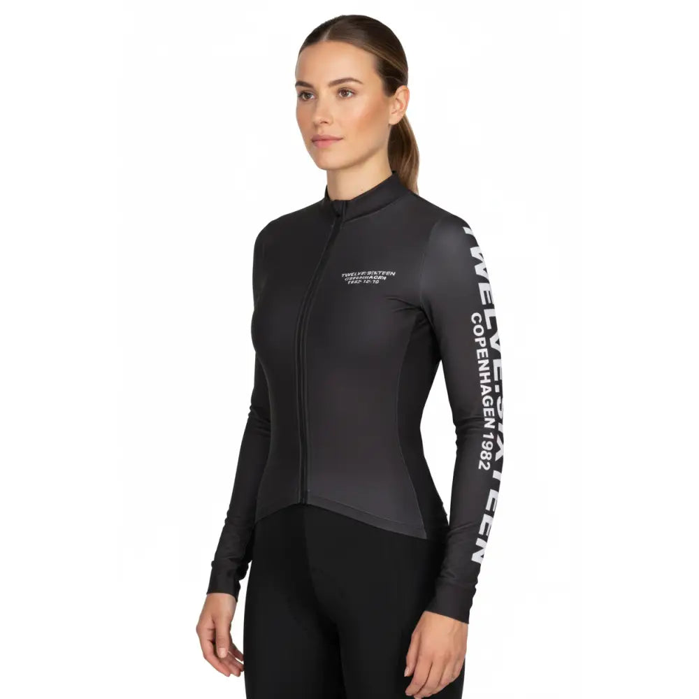 Woman wearing a black cycling outfit with visible branding 