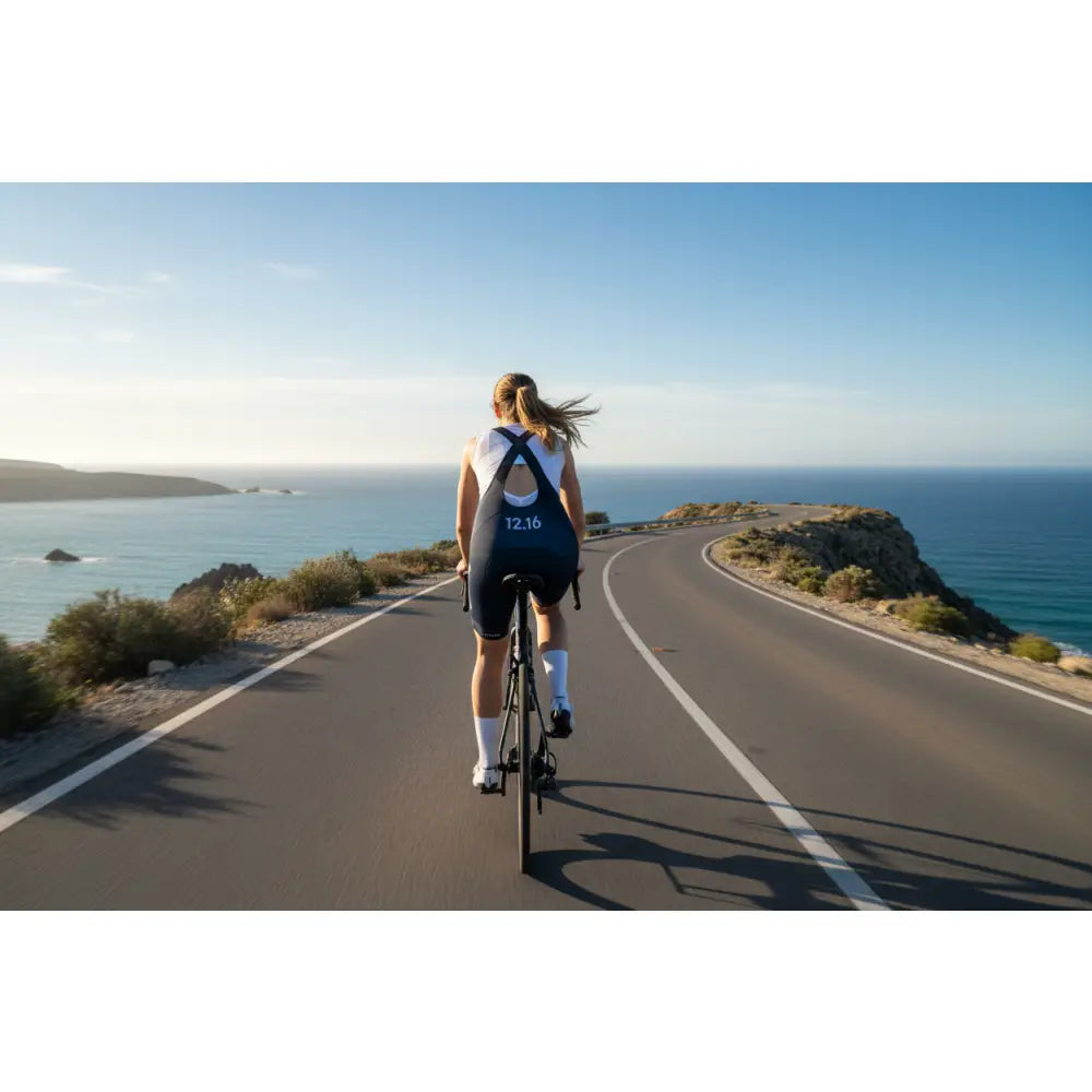 Person cycling on a road with ocean view
